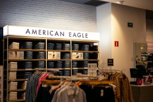 Interiör av en American Eagle-butik med jeanshyllor och klädställningar.