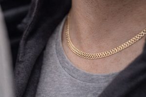 Närbild p&aring; ett gl&auml;nsande Bismarcks halsband i guld mot en personlig bakgrund.
